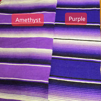 Striped fabric with 'Amethyst' and 'Purple' labels on a wooden surface