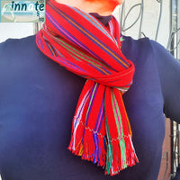 A person wearing a multicolored Mexican scarf with fringed edges.