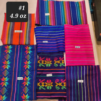 Colorful fabric samples with patterns and text labels on a flat surface