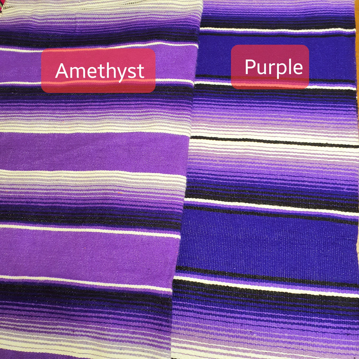 Striped fabric with 'Amethyst' and 'Purple' labels on a wooden surface