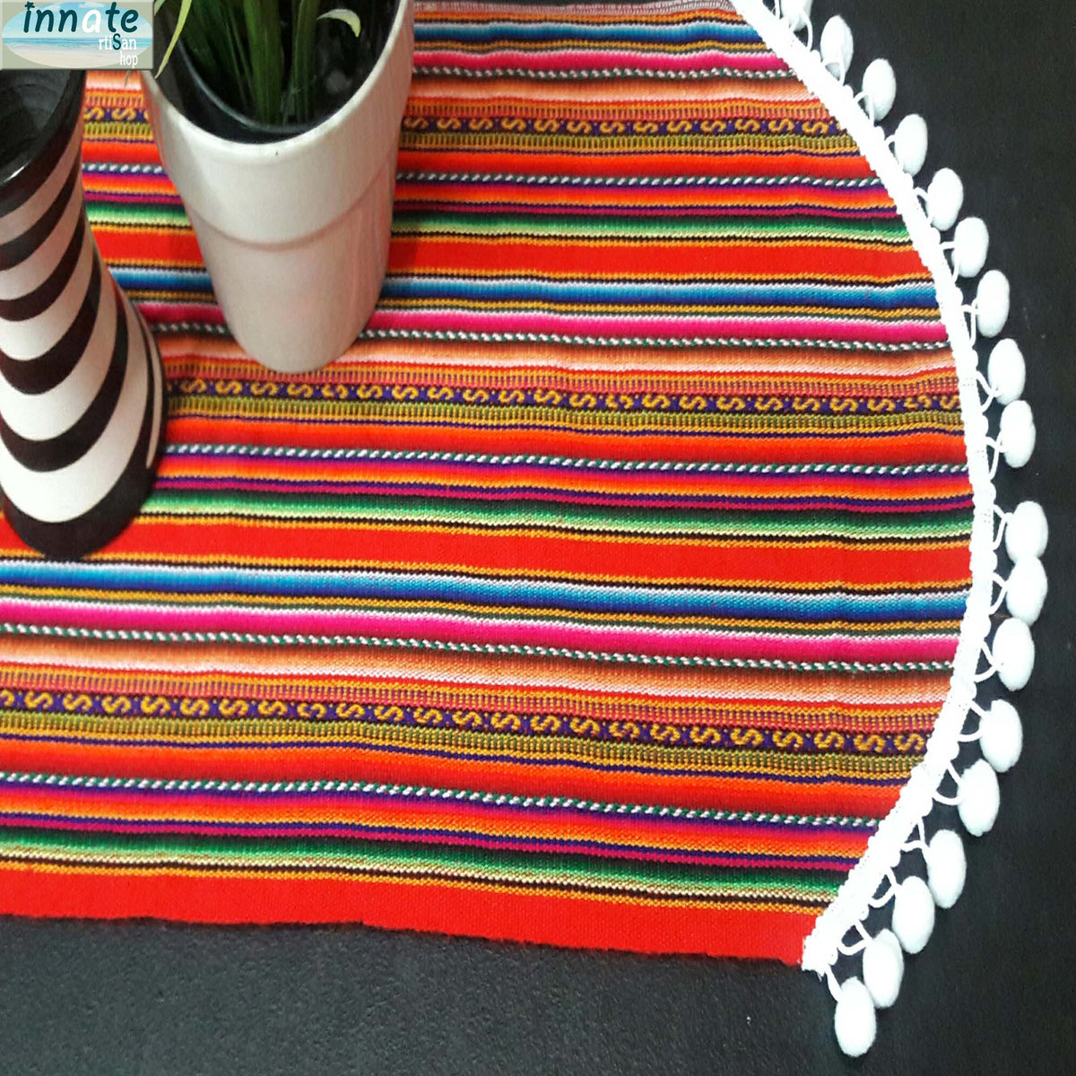 Colorful striped placemat with a white decorative edge on a black surface.