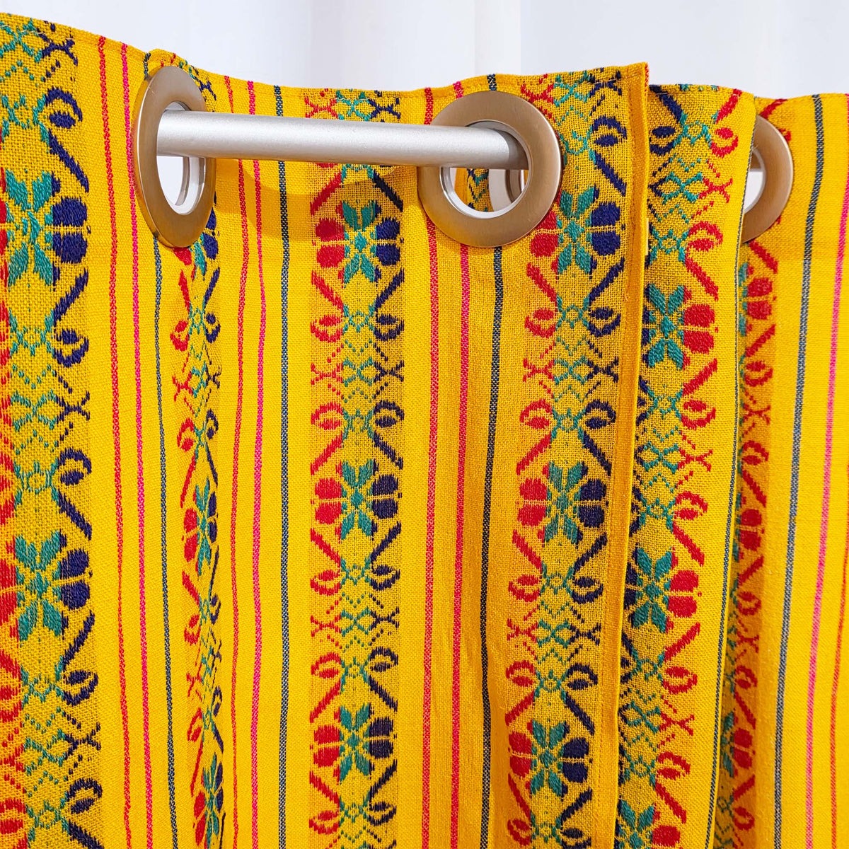Colorful patterned curtain with wooden rings on a yellow background