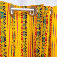 Colorful patterned curtain with wooden rings on a yellow background