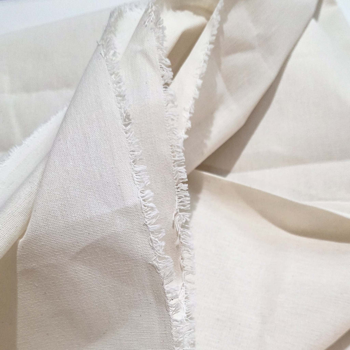 Close-up of beige fabric with frayed edge