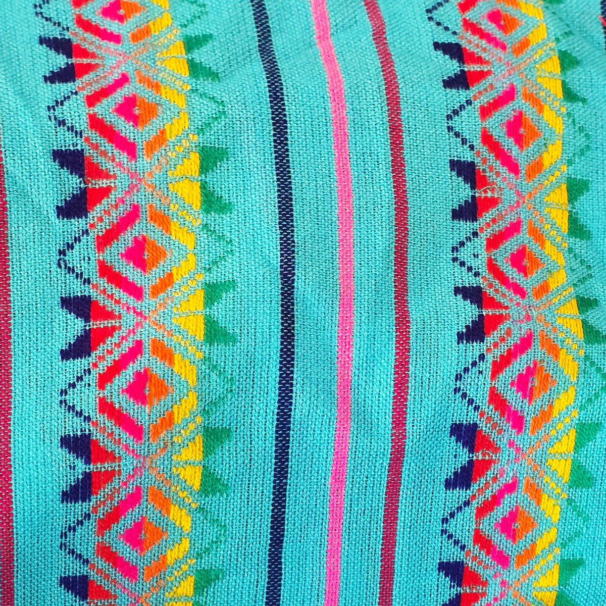 A close-up of a woven textile with a turquoise base and vertical geometric stripes in pink, red, yellow, green, and dark blue.