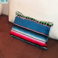 Colorful striped blanket draped over a white couch