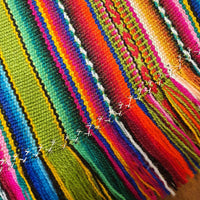 Close-up of colorful woven fabric with a wooden surface underneath