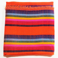 Colorful striped fabric with orange, red, pink, blue, and yellow stripes on a white background.