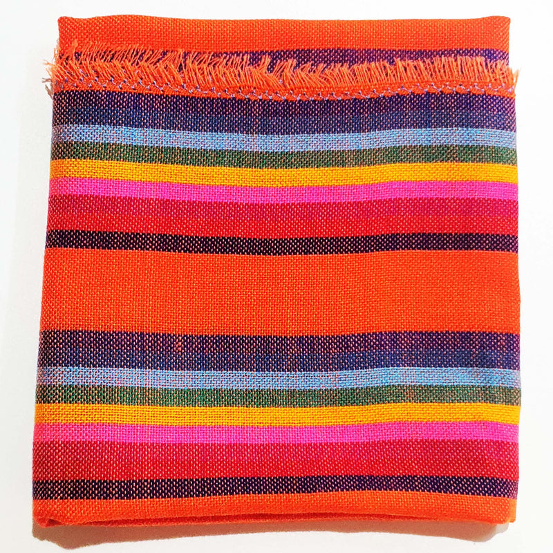 Colorful striped fabric with orange, red, pink, blue, and yellow stripes on a white background.