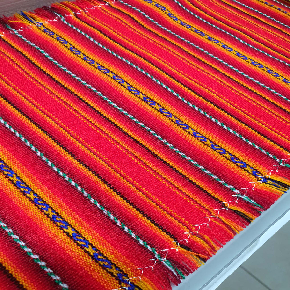 Close-up of a colorful tangerine woven fabric with multicolor patterns.