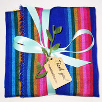 Colorful striped fabric with a blue ribbon and 'Thank you' tag on a white background