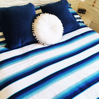 serape blanket, white, blue, on bed