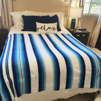 serape blanket, white, blue, on bed