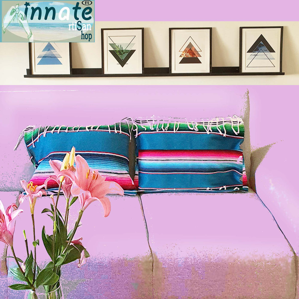 Colorful striped pillows on a bed with pink flowers and framed art on the wall.