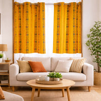 Living room with a beige sofa, wooden coffee table, and yellow patterned curtains.