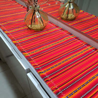Colorful striped table runner on a table with decorative vases.