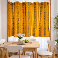 Dining room with a yellow patterned curtain, table, and chairs.