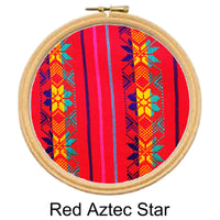 Embroidery hoop with red fabric featuring Aztec star pattern on a white background
