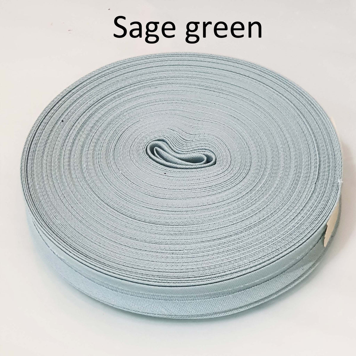 Sage green ribbon roll on a white background