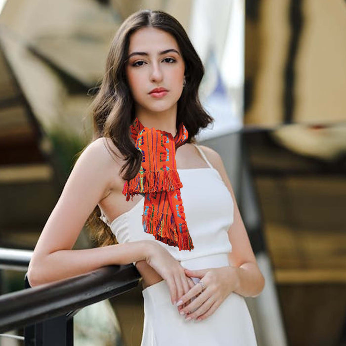 Woman wearing a white dress and orange scarf with blurred background