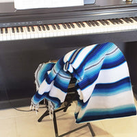 serape blanket, white, blue, over chair next to piano