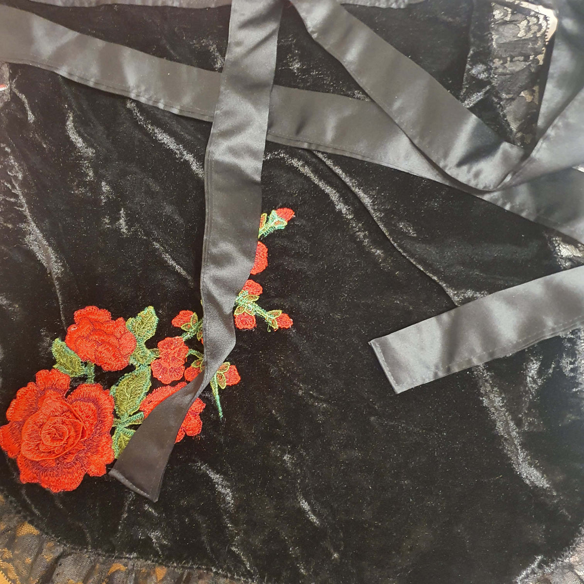 Black fabric with red floral embroidery and gray satin ribbon