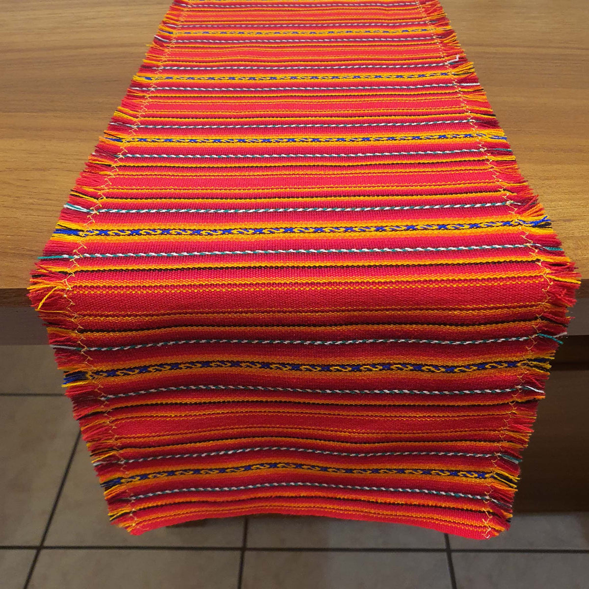 Vivid orange striped fabric on a wooden surface