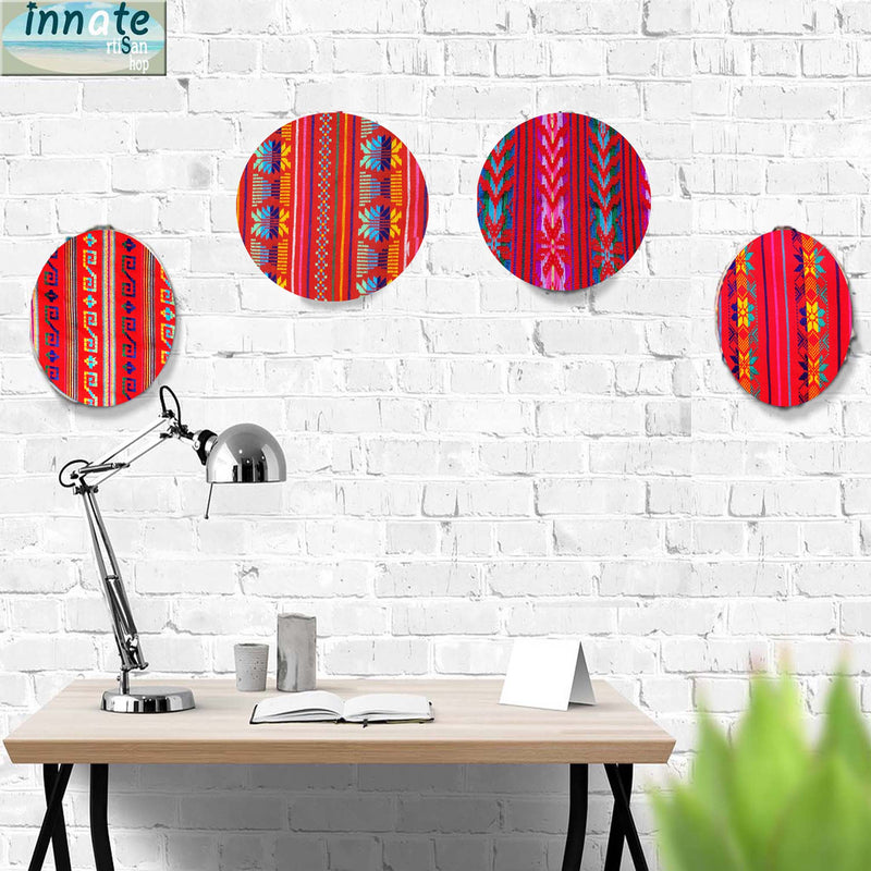 Colorful circular wall art pieces on a white brick wall with a desk and lamp in the foreground.